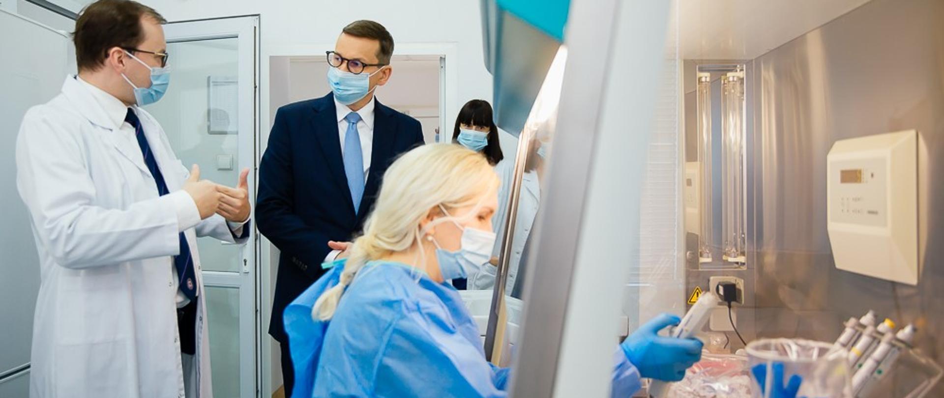 Premier rozmawia z lekarzem w laboratorium.