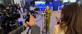 Minister funduszy i polityki regionalnej Katarzyna Pełczyńska-Nałęcz stoi przed mikrofonem, przed nią stoją dziennikarze