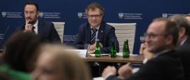 Wiceminister funduszy i polityki regionalnej Jacek Karnowski siedzi przy stole
