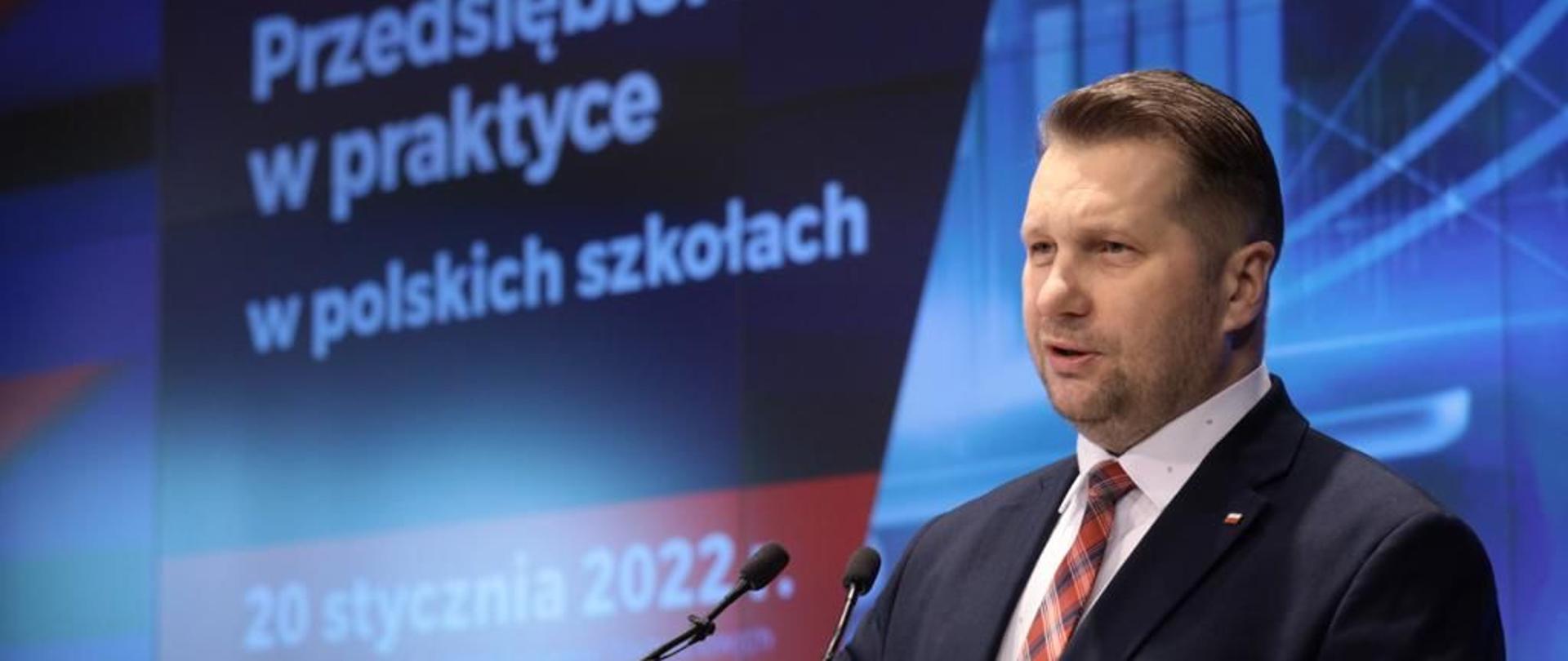 Praktyczne nauczanie przedsiębiorczości w szkołach – spotkanie z przedstawicielami biznesu z udziałem Ministra Edukacji i Nauki, minister Przemysłąw Czarnek przemawia podczas konferencji, z tyłu znajduje się telebim.