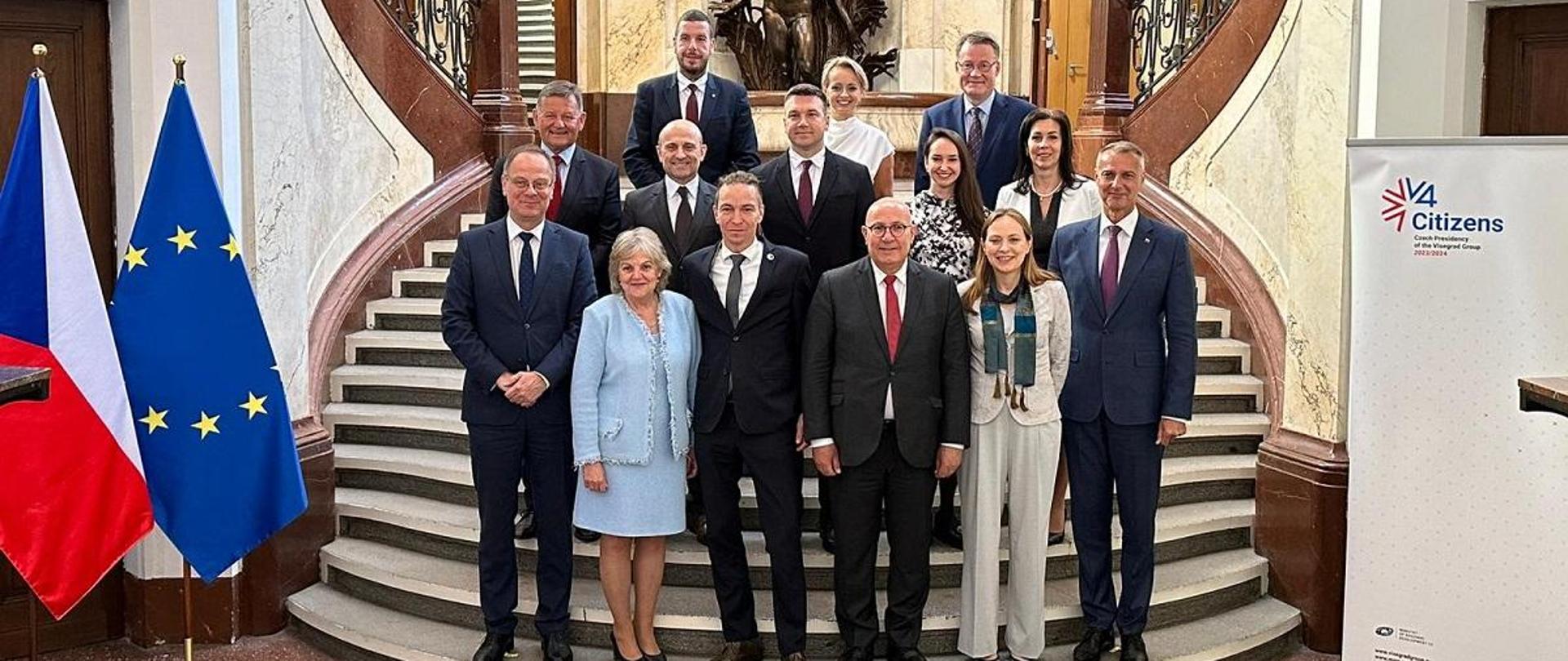 Minister Katarzyna Pełczyńska-Nałęcz pozuje do zdjęcia na schodach w towarzystwie pozostałych uczestników spotkania V4+7, druga z lewej w dolnym rządzie stoi komisarz ds. spójności i reform Elisa Ferreira 