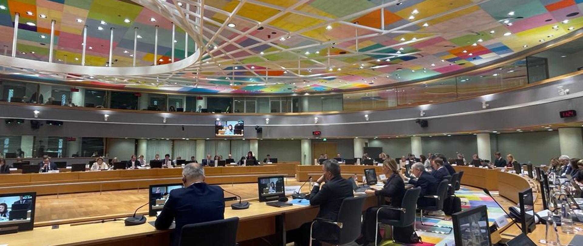 Kilka osób siedzi wokół okrągłego stołu.