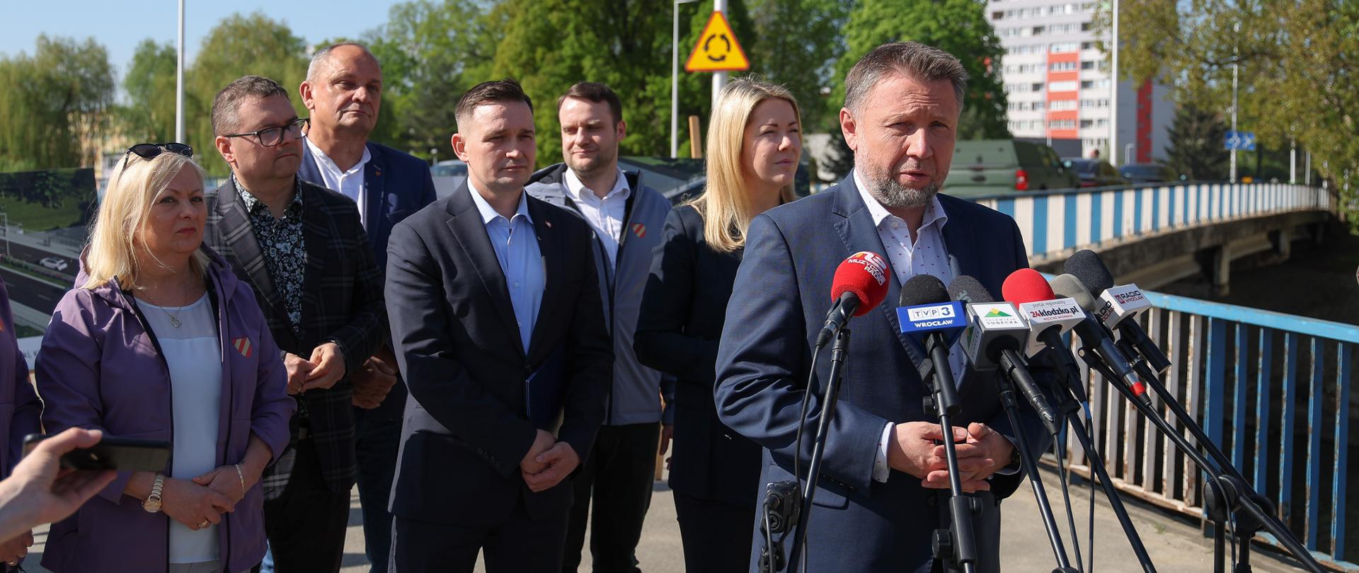 Minister Marcin Kierwiński, Minister Magdalena Roguska i Wiceminister Rozwoju i Technologii Michał Jaros podczas briefingu prasowego w Kłodzku. W tle lokalni samorządowcy.