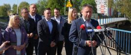 Minister Marcin Kierwiński, Minister Magdalena Roguska i Wiceminister Rozwoju i Technologii Michał Jaros podczas briefingu prasowego w Kłodzku. W tle lokalni samorządowcy.