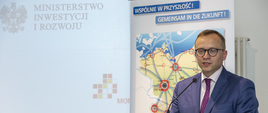 za pulpitem przed mikrofonem stoi wiceminister Artur Soboń