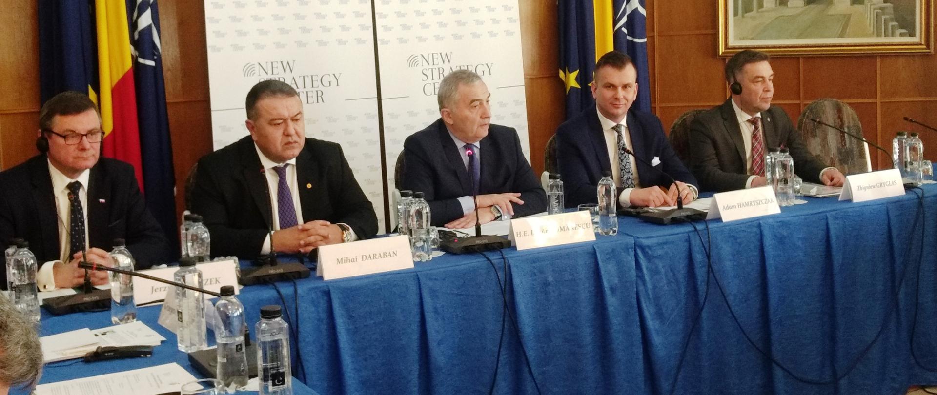 Przy stołach siedzą uczestnicy debaty. Wśród nich jest wiceminister Adam Hamryszczak.
