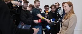 Minister funduszy i polityki regionalnej Katarzyna Pełczyńska-Nałęcz stoi przed mikrofonami trzymanymi przez dziennikarzy