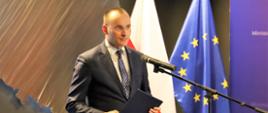 Mikołaj Pawlak - Rzecznik Praw Dziecka stoi przed mikrofonem i wypowiada się podczas konferencji.
