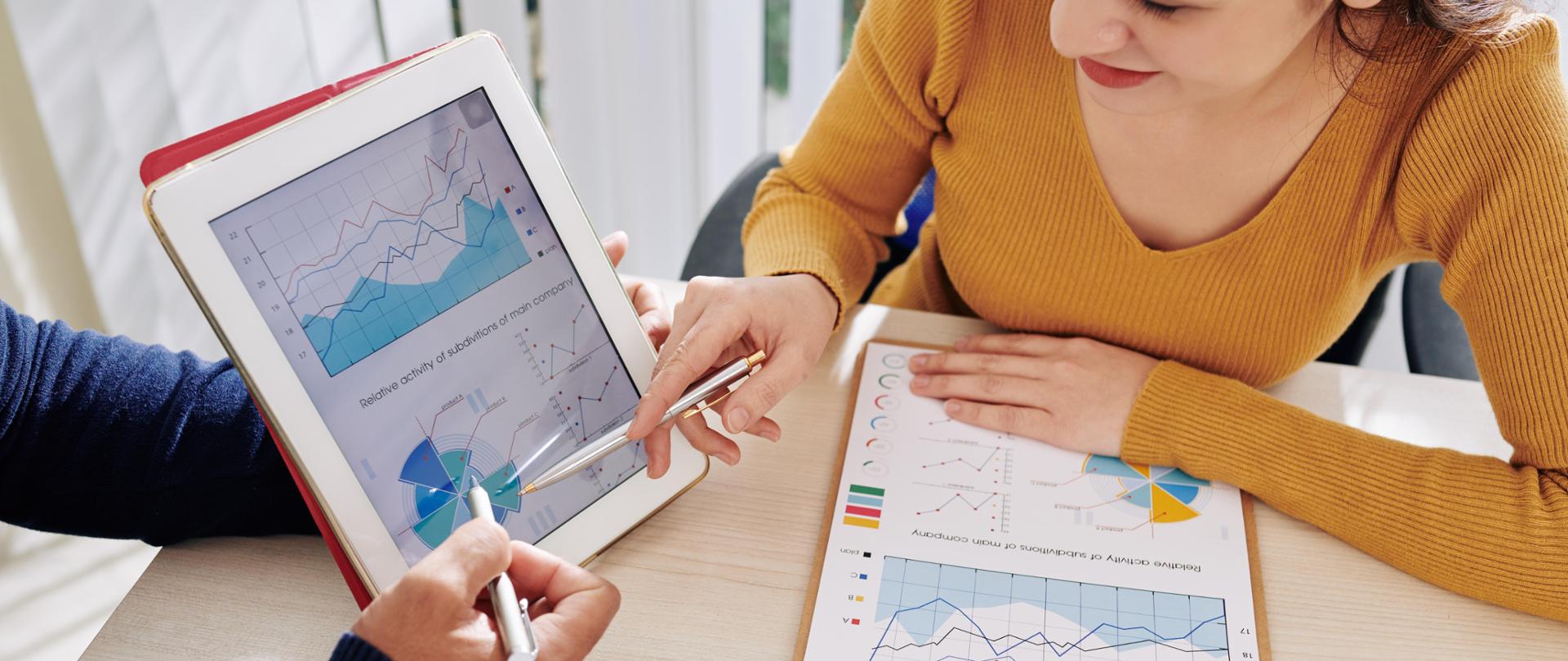 Cropped image of managers of finance department discussing information on tablet computer and making conclusions