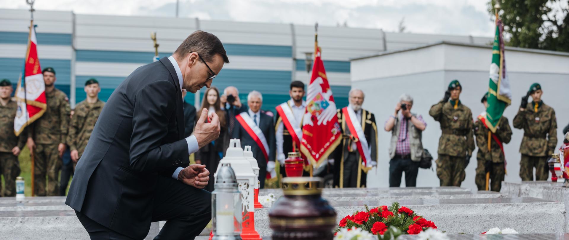 Premier składa znicze.