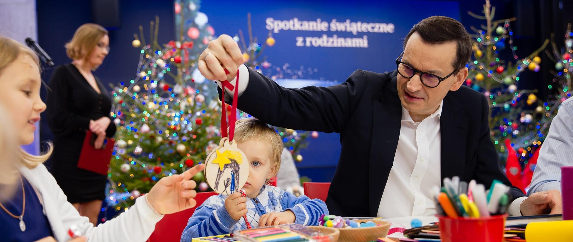 Premier siedzi z małym chłopcem.