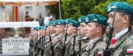 Zdjęcie z boku, szereg żołnierzy w zielonych beretach i z karabinkami, w tle ołtarz polowy na podwyższeniu.