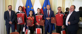 Minister Jan Widera z uczestnikami spotkania przy flagach