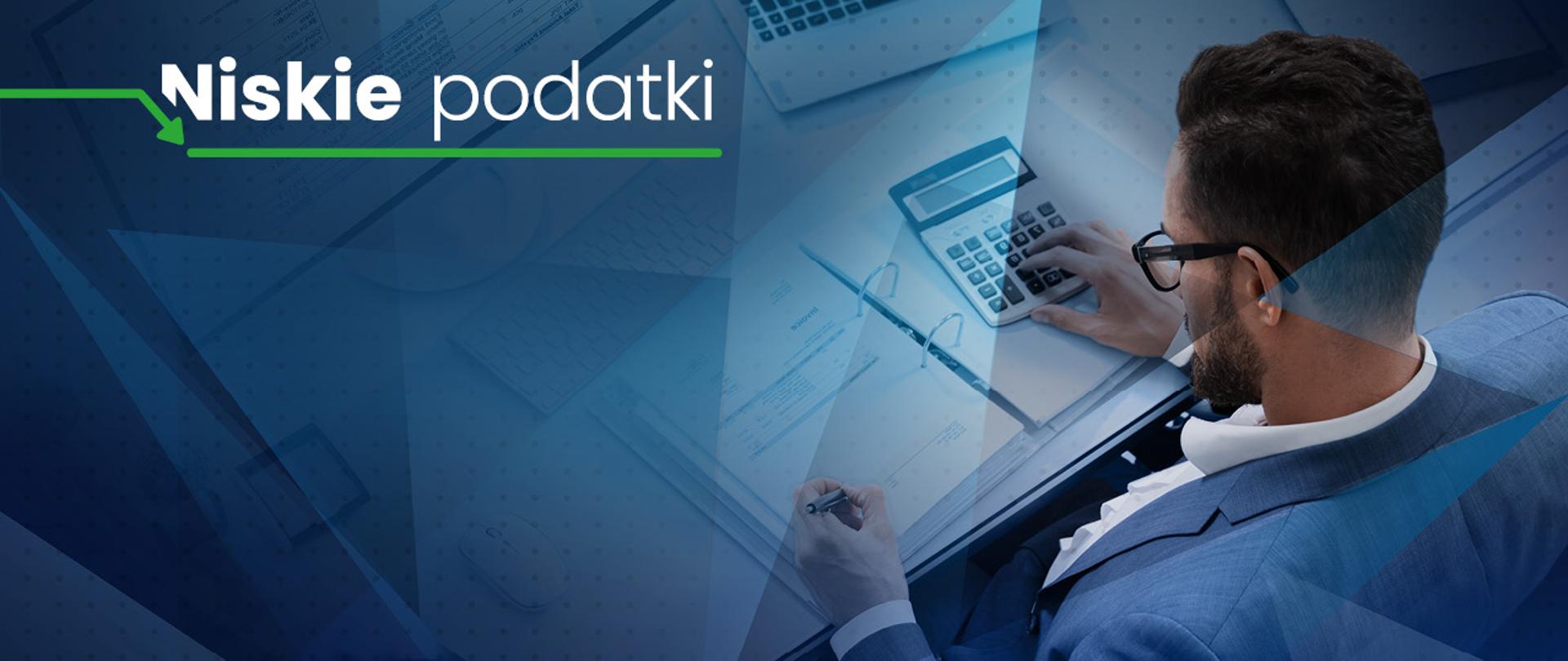 Napis Niskie podatki oraz mężczyzna z segregatorem i kalkulatorem