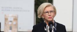 wiceminister Marzena Machałek podczas konferencji na tle 