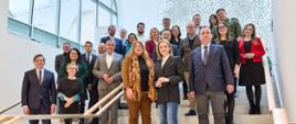 Zdjęcie zbiorowe na schodach stoi duża grupa ludzi i pozuje do zdjęcia