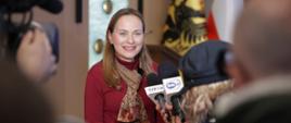 Na zdjęciu Minister Katarzyna Pełczyńska-Nałęcz przed mikrofonami odpowiada na pytania dziennikarzy