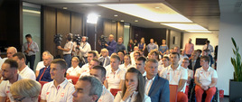 Sportowcy siedzą w rzędach