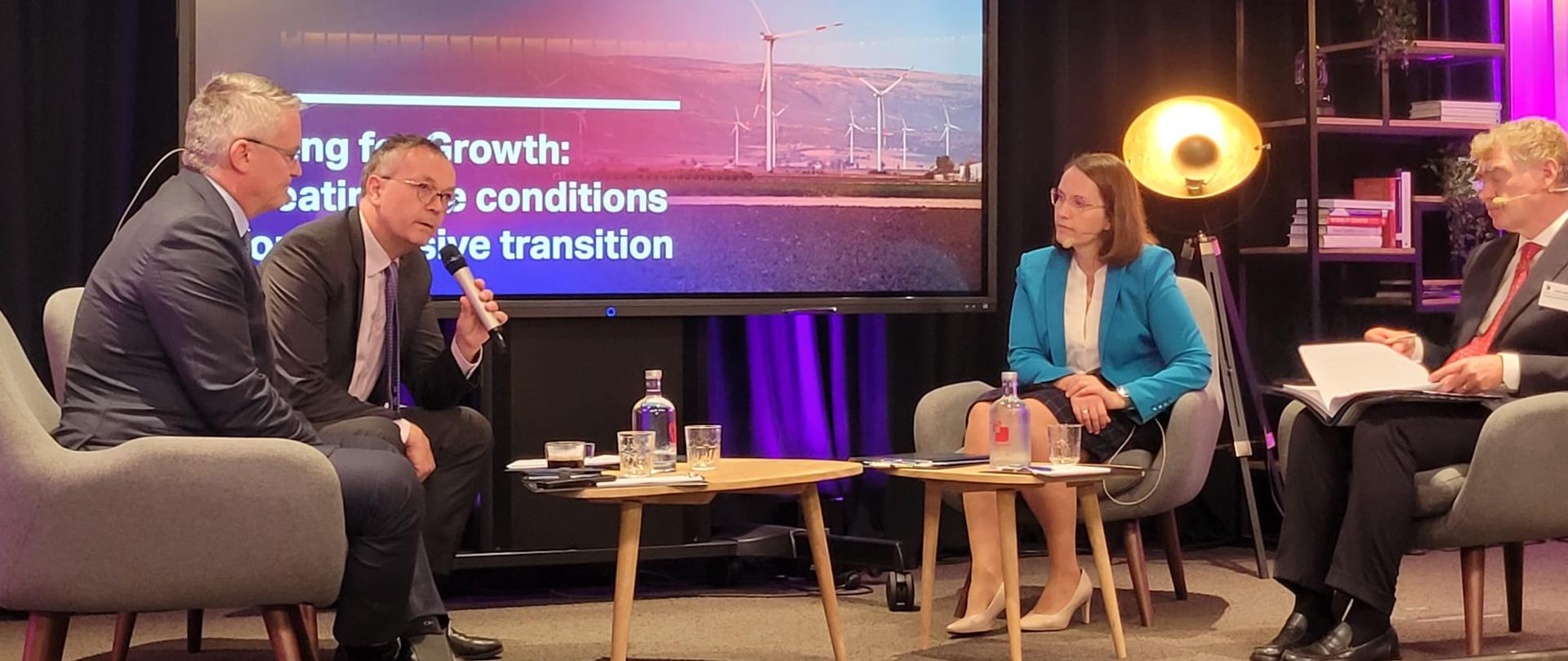 Minister finansów Magdalena Rzeczkowska siedzi przy stole z uczestnikami konferencji „Going for Growth” w Brukseli