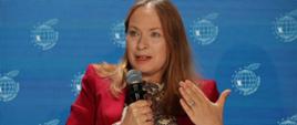 Minister funduszy i polityki regionalnej Katarzyna Pełczyńska-Nałęcz siedzi w fotelu i przemawia do mikrofonu