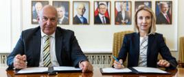 Minister Finansów Tadeusz Kościński i wiceprezes EBI Teresa Czerwińska na tle portretów byłych ministrów finansów