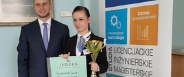 Zwyciężczyni z indeksem i pucharem. Z boku mężczyzna