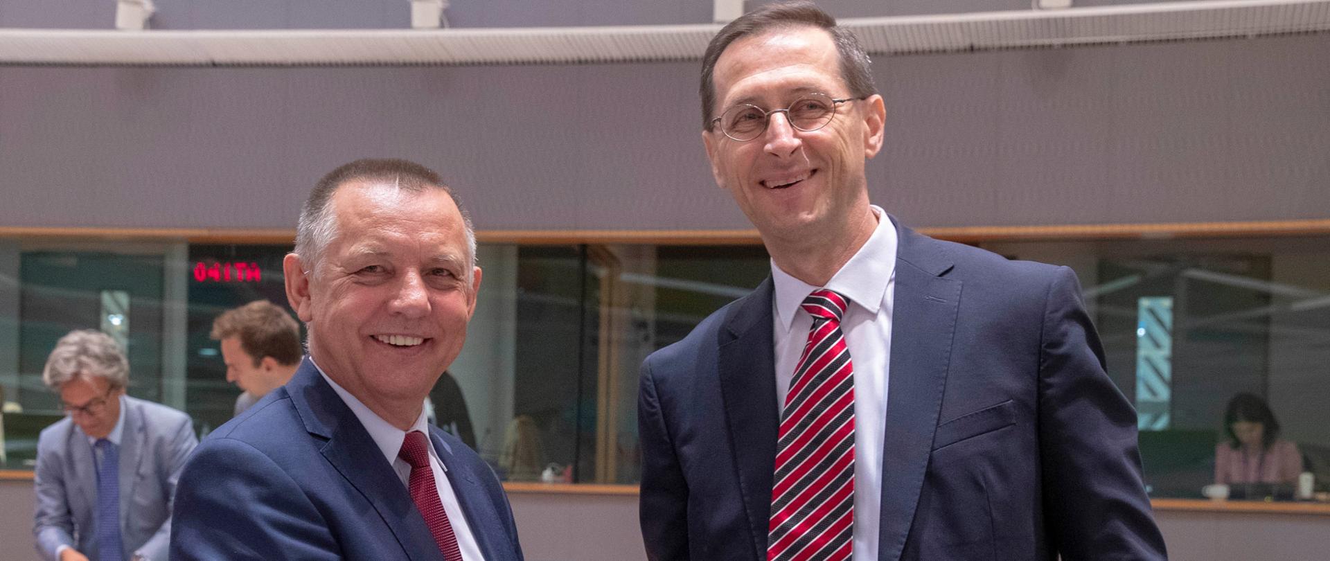 Uśmiechnięty minister finansów Marian Banaś ściska rękę ministra finansów Węgier