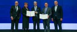 uczestnicy uroczystości prezentują podpisany list intencyjny: wiceprezes ARP Dariusz Śliwowski, ambasador Georgette Mosbacher, minister Jerzy Kwieciński, wiceprezes GE Renewable Energy Fabrice Kermorgant, prezes GE Power Sławomir Żygowski