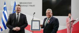 Minister Przemysław Czarnek oraz profesosor Nikolaos Papaioamou pozują do zdjęcia z odznaczeniami.