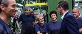 Premier wita się z pracownicą firmy.