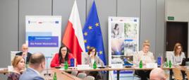 Zaproszeni goście siedzą przy dwóch stołach.