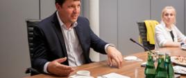 Czeski wiceminister Waldemar Piecha przy stole konferencyjnym, obok siedzi uczestniczka konferencji