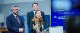Na zdjęciu minister Katarzyna Pełczyńska-Nałęcz stoi przy mównicy w towarzystwie innych uczestników konferencji